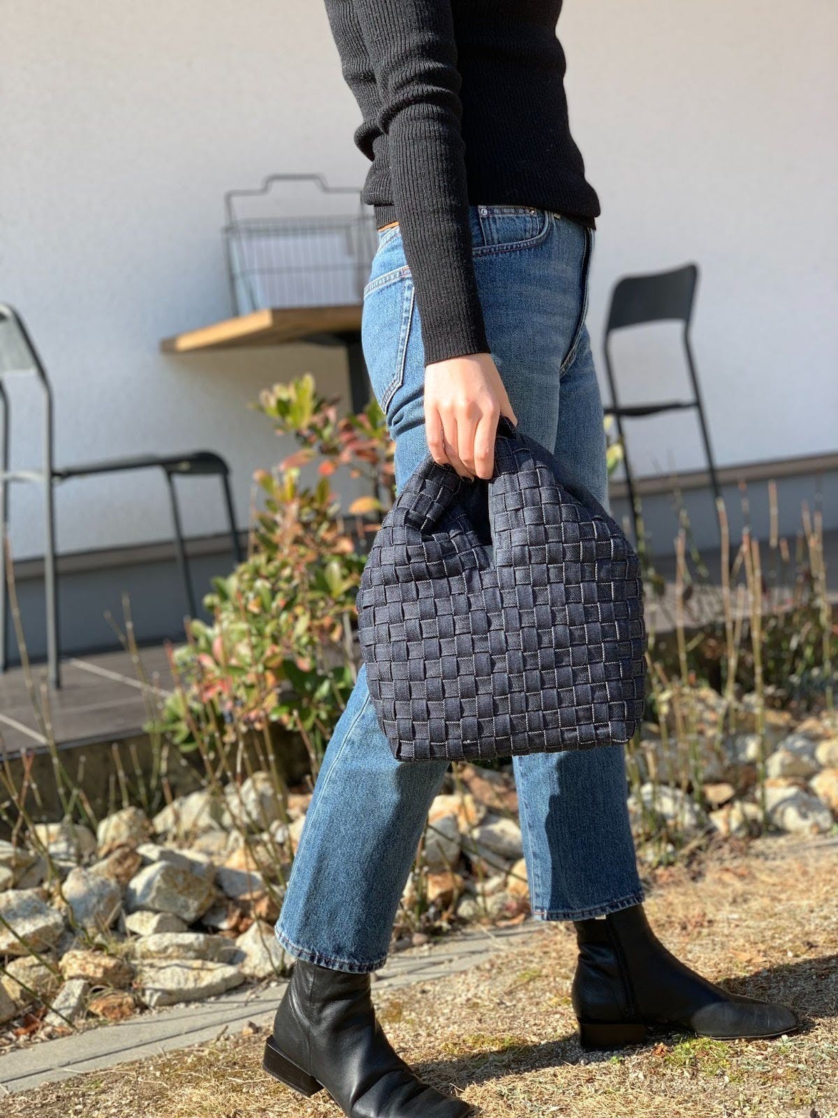 片手で持つのにバランスのいいコンパクトサイズと華美過ぎない控えめなデザイン、重厚感のある生地が、カジュアル過ぎず大人の装いに品よくマッチします。500mlのペットボトルも収まる実用性の高さや、荷物の出し入れがしやすい大きな間口が特徴。 内側にマグホックと、オープンフラットポケットが一つ付いています。 ジーンズのベルトループから着想を得たデニムプロダクトシリーズ。 倉敷市児島のジーンズ工場で生産の過程でうまれたデニム残布を縫製職人の手で紐状の生地に加工。丈夫で経年にも耐えうる紐状のデニムは、三つ折りにして縫製されているため強度があり長期使用にも耐えることができます。紐を一本一本手作業で編み込み、独特の手法で立体的に形作られていくことによって、デニム本来の柔らかな美しさを引き立てます。 今ある資源、本来廃棄される素材の再利用を最大限に目指しながらも、製品自体には傷の部分が含まれないよう細心の注意を払って製作しています。 サイズ(ONE SIZE) 本体:縦18cm× 横22cm × マチ10cm 持ち手の長さ:14cm カラー: 掲載写真はインディゴ(インディゴステッチ)です。